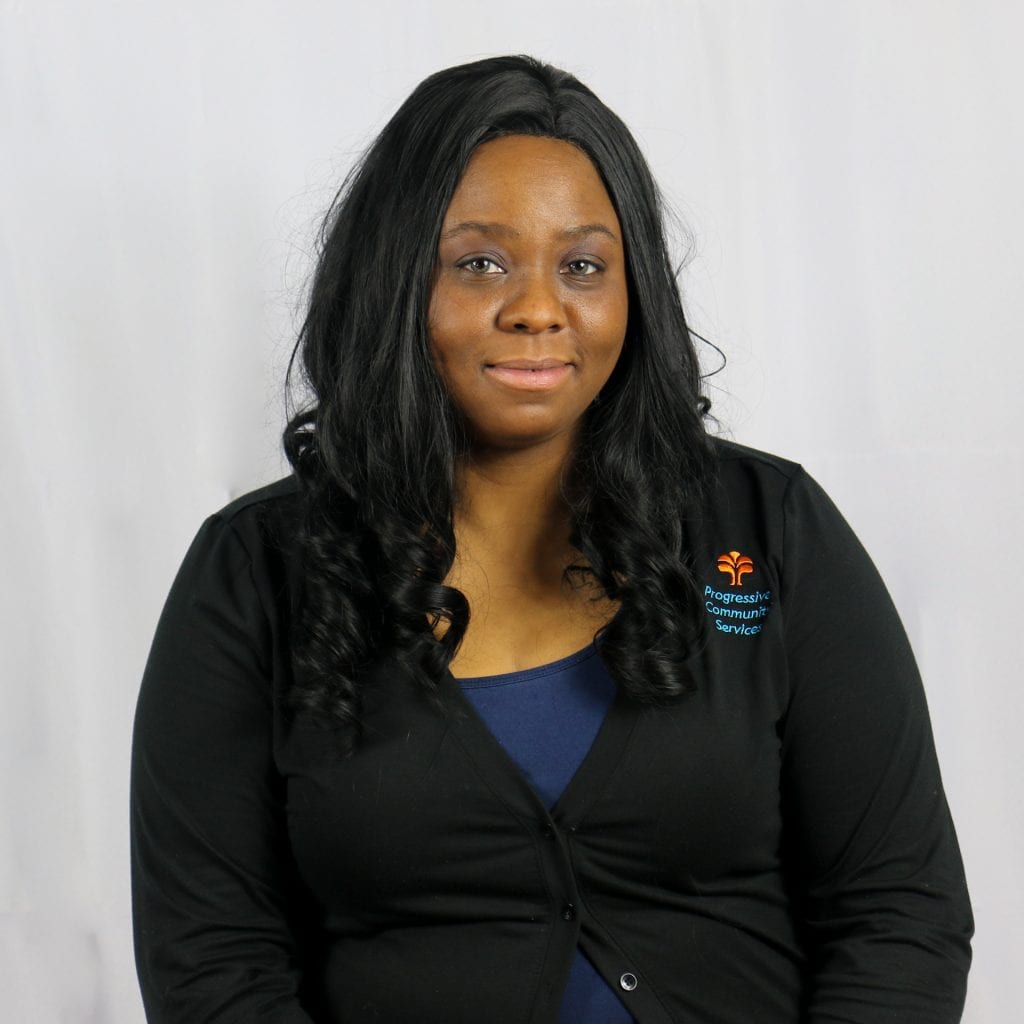 Black female with long dark wavy hair wearing a black sweater.