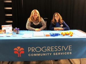 PCS employees sitting behind a display table